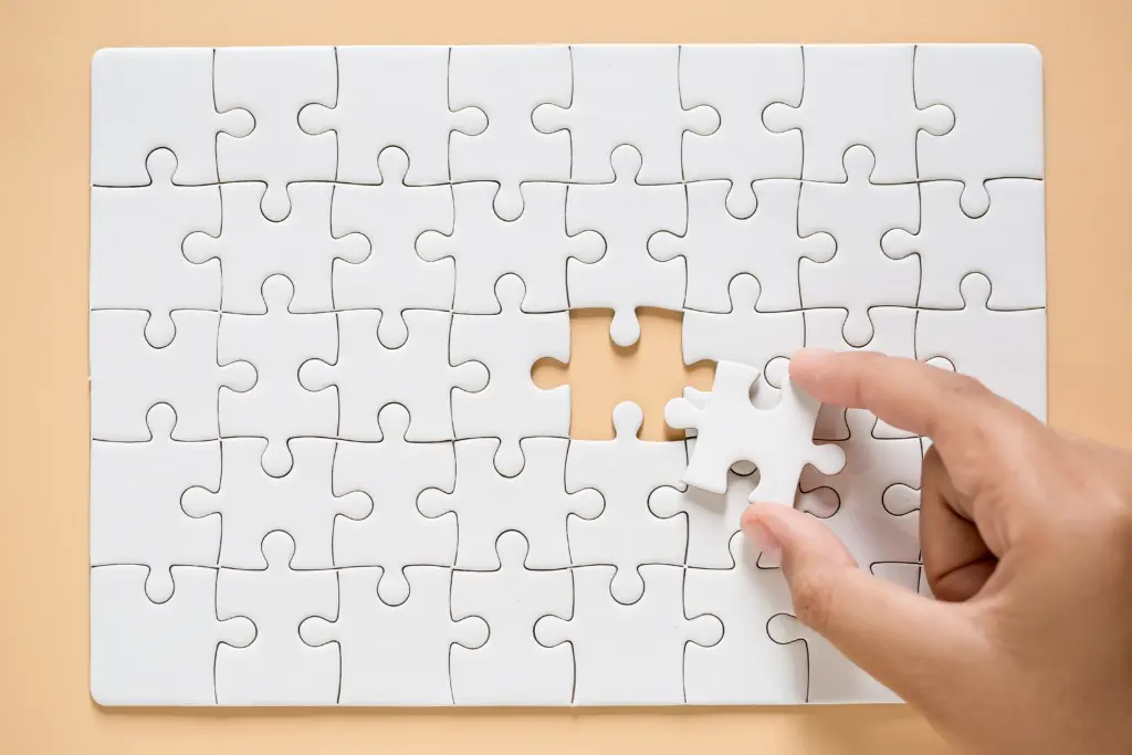 hand connecting puzzle pieces table background