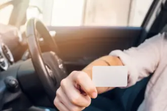 man showing business card car
